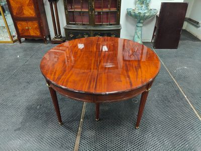 une photo d'une table ronde avec un plateau en bois dans une pièce