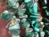 some very pretty green and green beads on a table