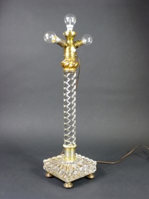 une image représentant une lampe de table en or et en cristal sur fond noir