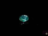 a close up of a green diamond on a black surface