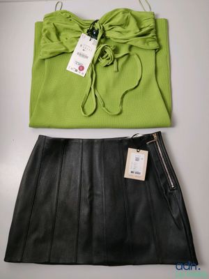 un haut vert et une jupe en cuir noir avec une étiquette dessus