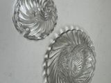pair of clear glass wall sconces on a white surface