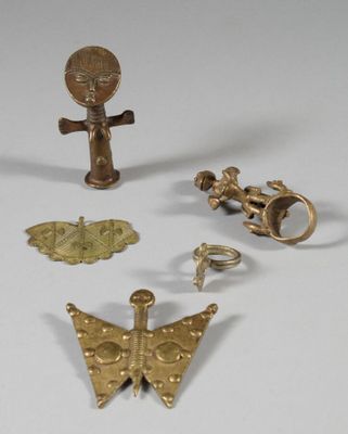 several pieces of gold are displayed on a white surface