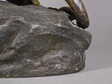 a statue of a bird perched on a rock
