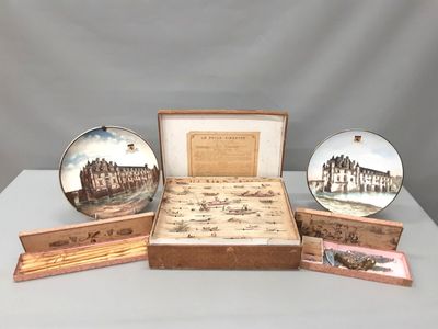 three plates and a box with a picture of a castle on it