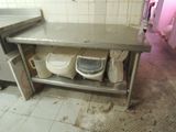 a dirty kitchen with a sink and a trash can in it