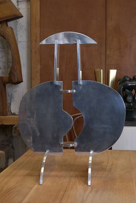 une sculpture en métal posée sur une table en bois dans une cuisine