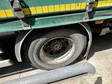 a green truck with a yellow stripe parked on the side of the road