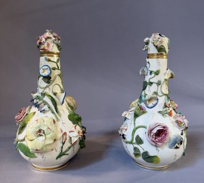 pair of porcelain vases with floral designs on them on a gray background