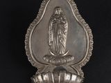 une image représentant une cuillère en argent sur laquelle figure la statue d'une femme