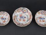 three chinese porcelain bowls and a bowl on a black surface