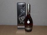 La bouteille de brandy se trouve à côté de la boîte, sur la table.