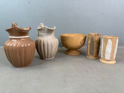 Plusieurs vases et tasses sont alignés sur une table