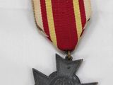 an old medal with a star on it sitting on a white surface