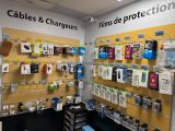 une photo d'un magasin de téléphones portables avec de nombreux appareils électroniques accrochés au mur