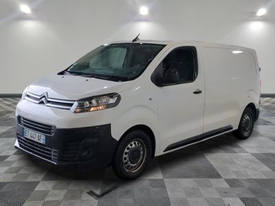 la camionnette blanche est garée sur un sol en damier dans le garage