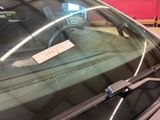 a sticker on the windshield of a car that is parked in a parking lot