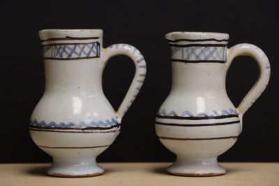 two white and blue vases sitting on a table