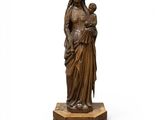 une statue en bronze d'une femme tenant un enfant dans ses bras