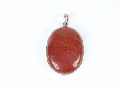 a close up of a red stone pendant on a white background