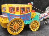 a toy horse pulling a carriage with people in it
