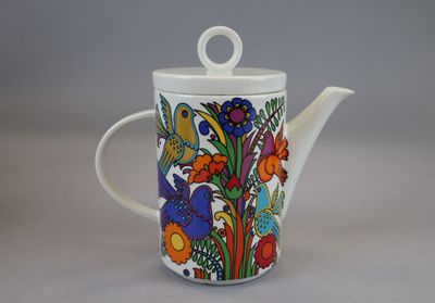 a white tea pot with a colorful floral design on it