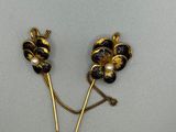 paire d'épingles à cheveux noires et dorées en forme de fleur, ornées de perles