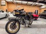 une moto garée dans un garage à côté d'autres voitures