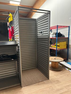 une photo d'une pièce avec une porte métallique et des étagères