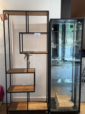 une vitrine en verre avec des étagères et un porte-serviettes dans un coin