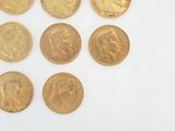 several gold coins are arranged in a row on a white surface