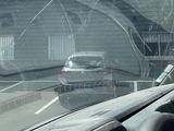 a view of a car driving down the road from inside a car