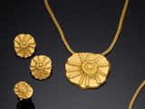 an image of a gold necklace, earrings and ring on a black surface