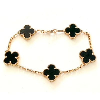 un gros plan sur un bracelet orné de quatre fleurs noires