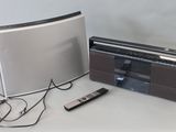 une radio et une télécommande posées sur une table à côté d'un haut-parleur