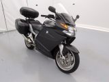 une moto noire garée dans une pièce aux murs blancs