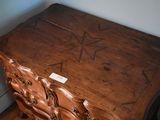 a wooden chest of drawers with a star on it