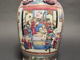 a vase with a painting on it sitting on a table