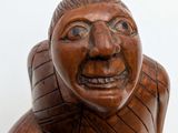 carved wooden statue of a man with a surprised look on his face