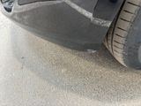a close up of a car ' s front bumper and tire