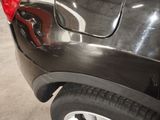 a close up of a black car with a red tail light
