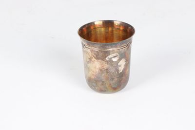 an old silver cup on a white surface with a white background