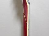 a close up of a red electric guitar on a stand