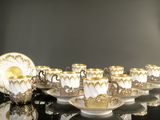 several cups and saucers are lined up on a black table