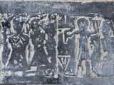 une image représentant une plaque en pierre sur laquelle figure un groupe de personnes