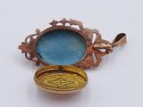 a small gold locke with a blue glass in it