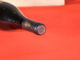 a bottle of wine sitting on a red cloth