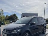 une camionnette noire sur une remorque à plateau dans un parking