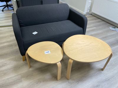 un canapé noir et deux tables en bois dans un salon