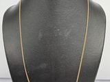 a black mannequin with a gold chain on it